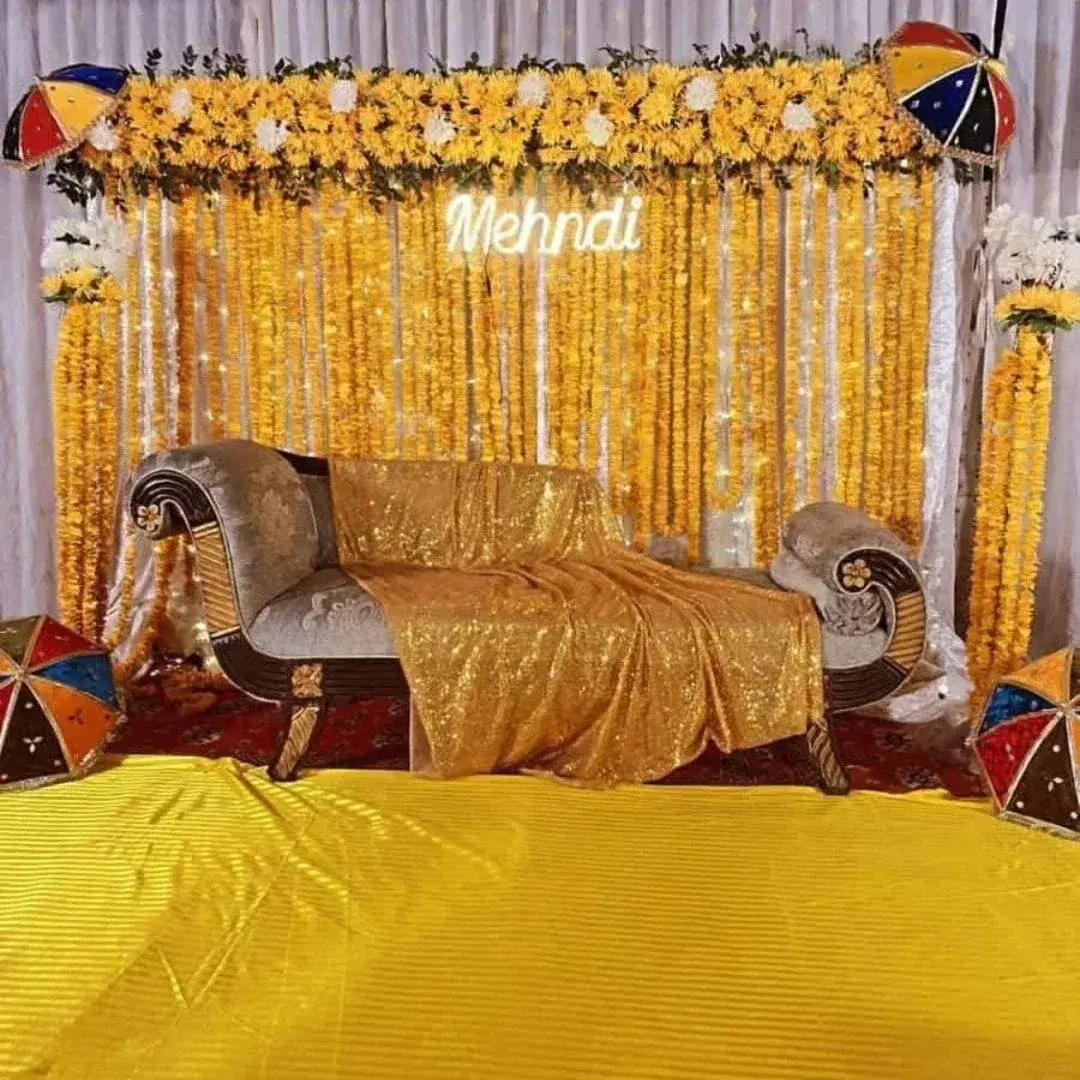 Traditional Mehndi Setup with Marigold Backdrop, Neon Sign and Fairy Lights